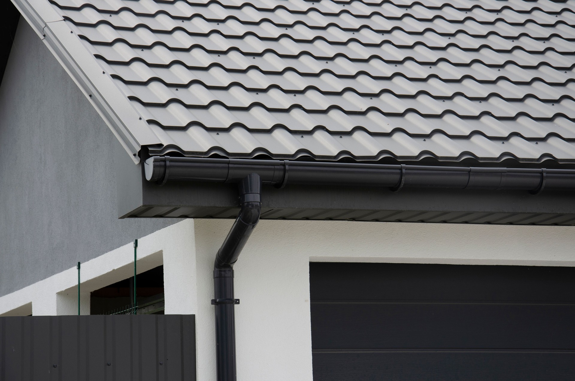 Black plastic gutter system and  metal tile on the roof